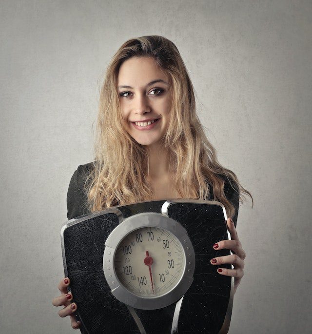 How Much Should I Weigh Myself? lady with a scale